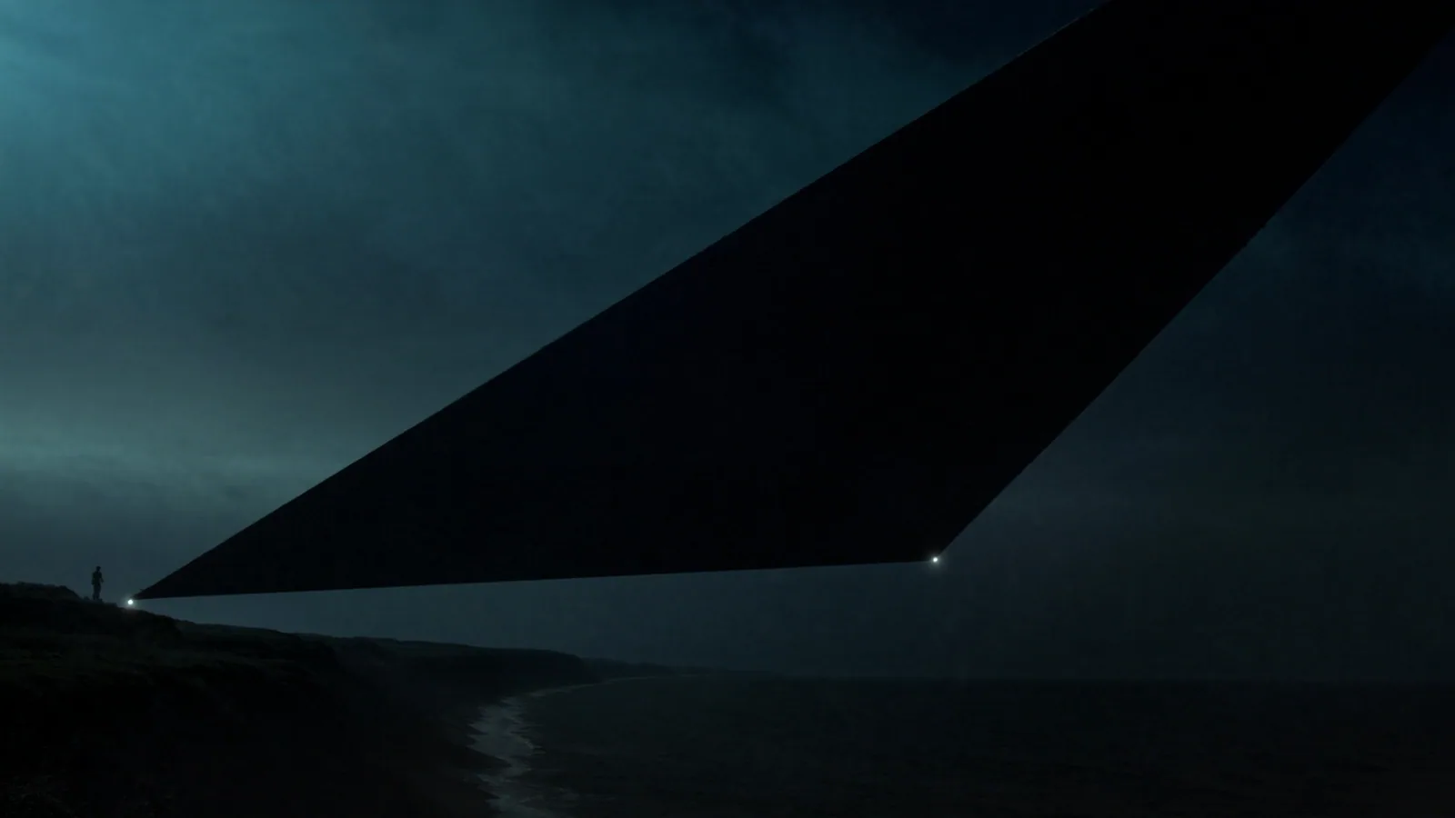 A dark triangular craft silhouette holding altitude over a moonlit Pacific coastline at night.